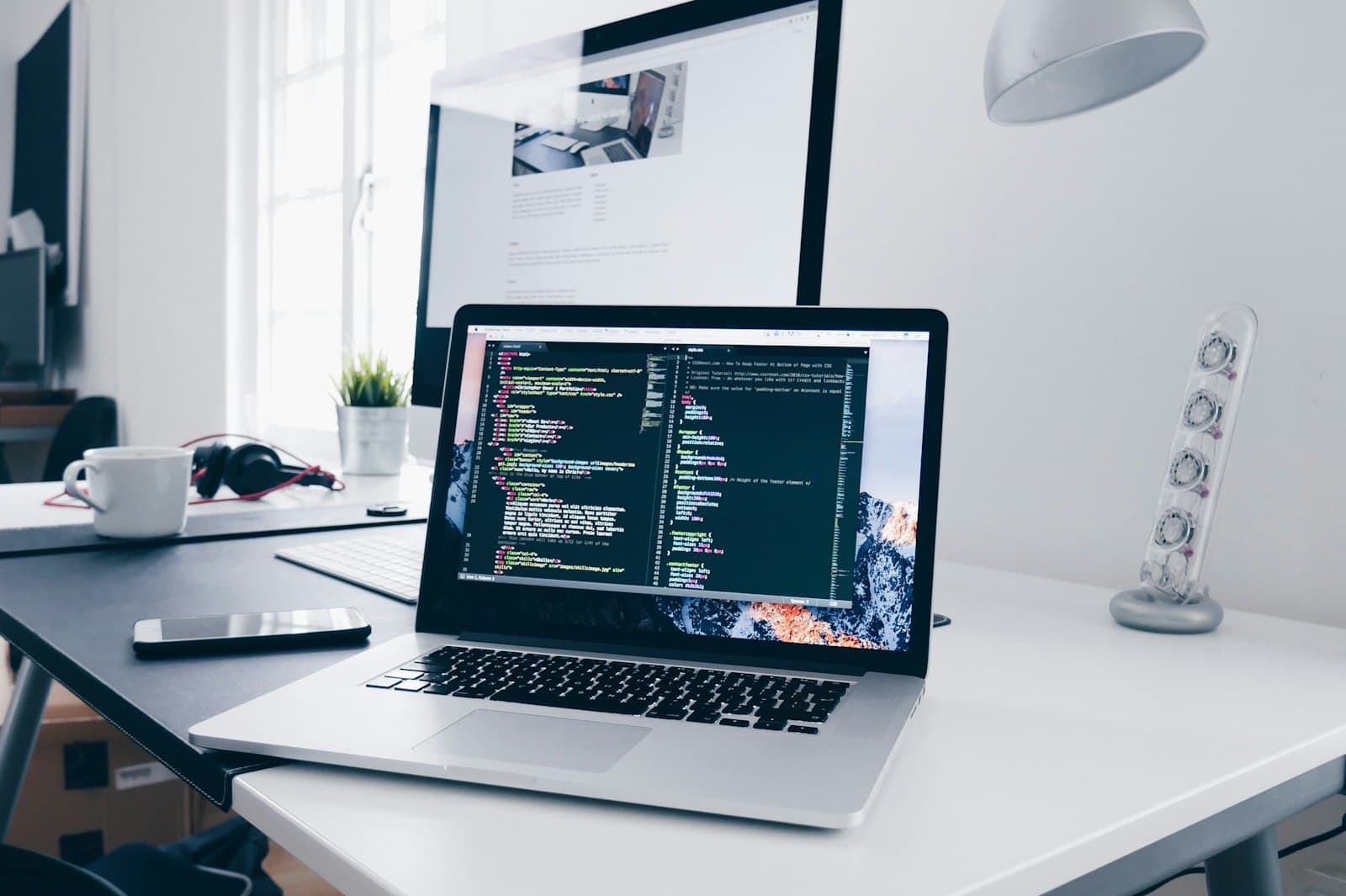 Developer working on a laptop with code on screen
